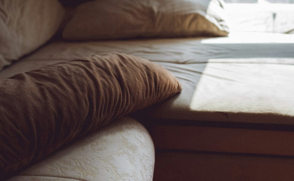 Bed with pillows near a window
